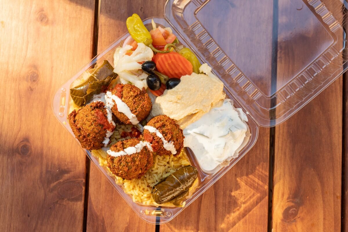 Falafel over rice with fresh vegetables and sauce