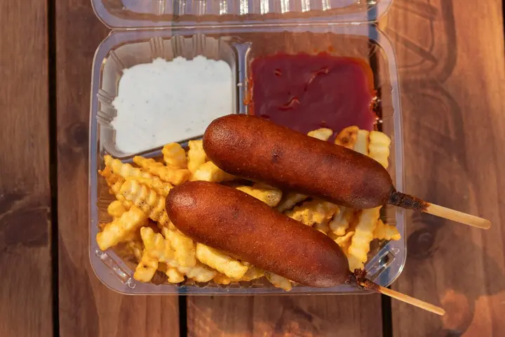 Corn dog meal with fries and a drink